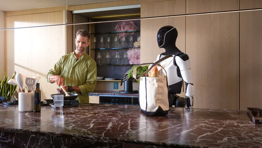 A person standing next to a robot
Description automatically generated