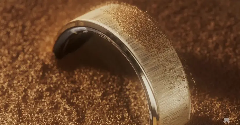 A gold ring with a black center
Description automatically generated