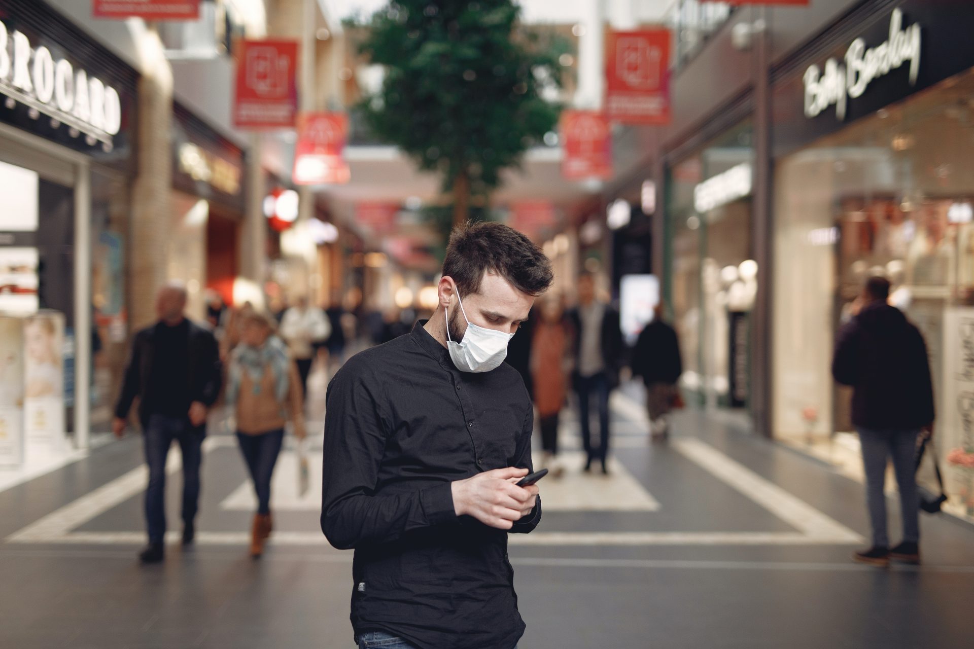 young-man-in-disposable-mask-using-smartphone-in-middle-of-3983435.jpg